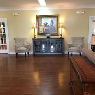 A cozy living room with elegant furniture and artwork on the wall.