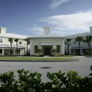A modern building with palm trees under a clear sky.