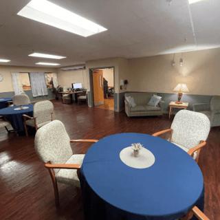 A cozy lounge area featuring a round table with a blue tablecloth and comfortable seating.