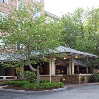 A building entrance surrounded by trees and well-maintained landscaping.