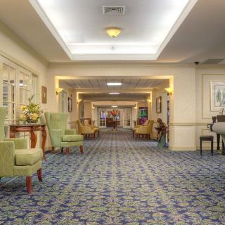 A hotel hallway with seating areas and decorative lighting.