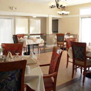 An empty restaurant dining area with neatly arranged tables and chairs.