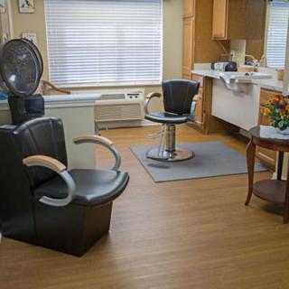 A cozy hair salon with styling chairs and a dryer station.