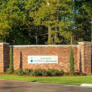 Entrance sign for a residential community surrounded by trees and landscaping.