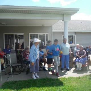 A group of elderly individuals enjoying a sunny day on a patio.