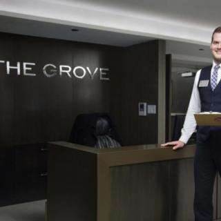 A hotel employee stands at the reception desk in the lobby of The Grove.