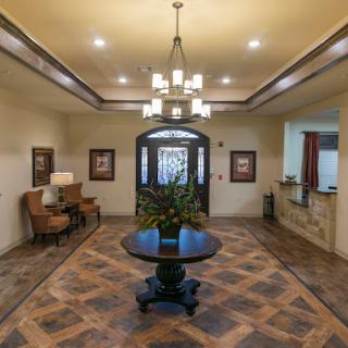 A beautifully designed lobby featuring elegant furniture, a central decorative table with plants, and bright lighting.