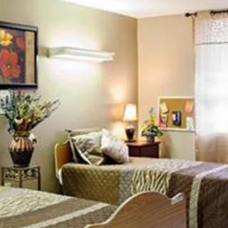 A cozy bedroom with two beds, soft lighting, and elegant decor.