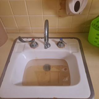 A kitchen sink filled with water, showcasing the faucet and surrounding area.