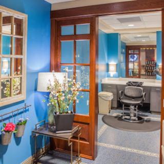 A modern workspace with blue walls, featuring a comfortable chair and stylish decor.