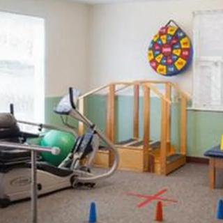 A rehabilitation room featuring exercise equipment and therapy tools.