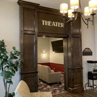 Entrance to a cozy theater room with plush seating and elegant lighting.