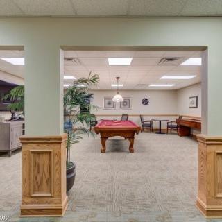 A spacious recreation room featuring a pool table and comfortable seating.