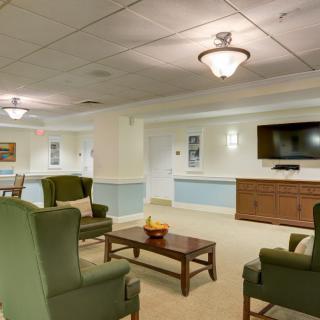 A cozy seating area with comfortable chairs, a television, and warm lighting.