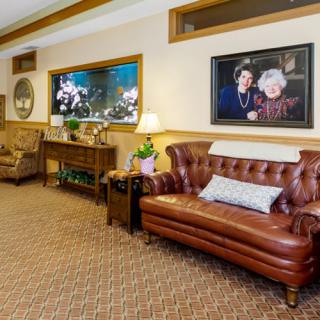 A cozy living room with a leather sofa, an aquarium, and decorative wall art.