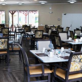 An empty restaurant dining room with neatly arranged tables and chairs.