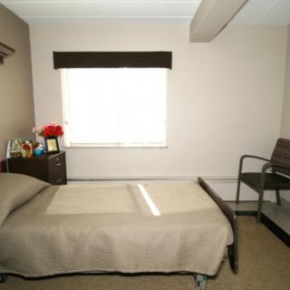 A minimalist bedroom with a single bed and a window.