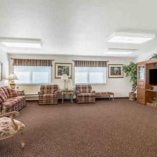 A traditional living room with plaid furniture and a television.
