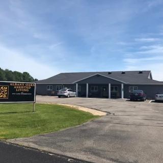 A church building with a parking lot and sign on a cloudy day.