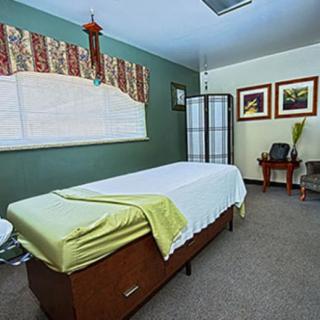 A tranquil massage room with a treatment table and serene decor.