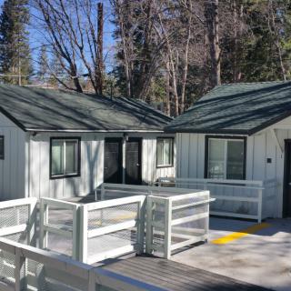Small cabins nestled in a forest setting with wooden walkways.