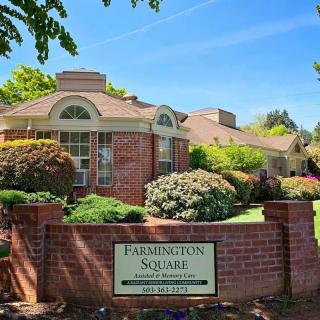 A charming brick residential building named Laddington Square surrounded by well-maintained gardens and greenery.