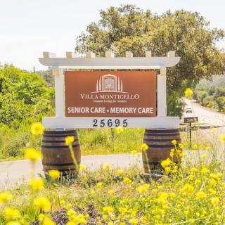 A scenic view of a winery sign surrounded by vibrant yellow flowers and lush greenery.