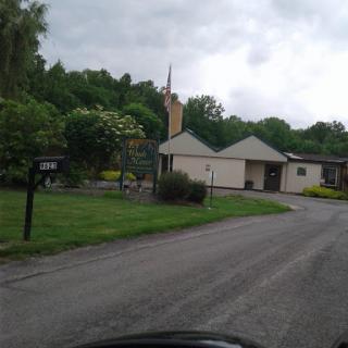 A quiet residential area with lush greenery and a cloudy sky.