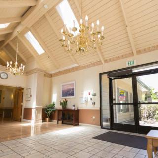 Spacious lobby area with chandeliers and natural light from skylights.