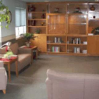 A cozy waiting room with comfortable seating and a large bookshelf.