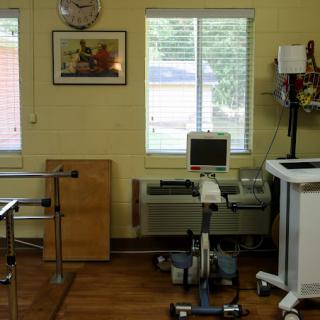 A therapeutic room equipped with various medical devices and sunlight filtering through the window.