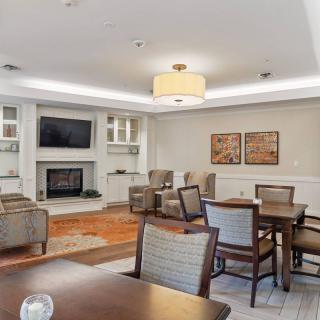 A modern living room with comfortable seating, a television above a fireplace, and tasteful decor.