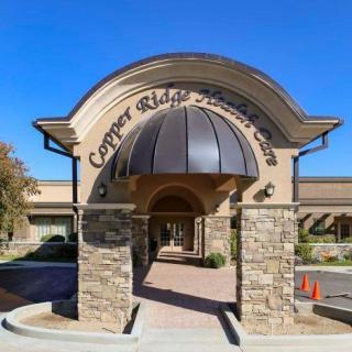 Entrance of a building with stone columns and an arched awning.