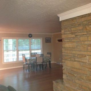 A cozy living space featuring a dining area with large windows and a stone accent wall.