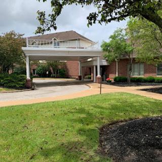 A welcoming entrance to a facility, surrounded by greenery.