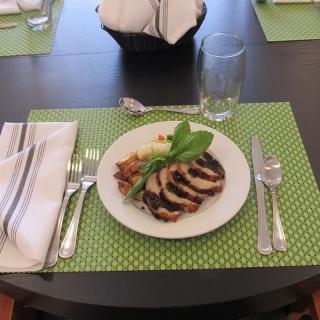 A neatly set dining table with a plated meal on a green placemat.