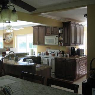 A kitchen featuring wooden cabinets, appliances, and a dining area.