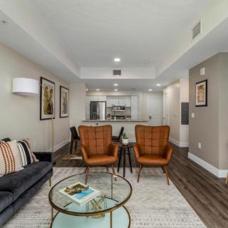 A modern open-plan living room with stylish furniture and a connected kitchen.