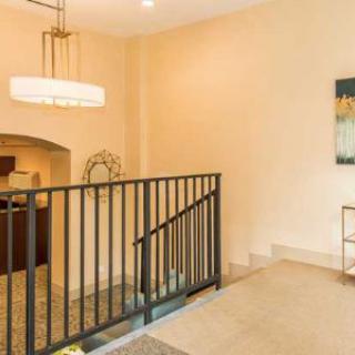A modern interior space featuring a staircase with a sleek railing, contemporary lighting, and decorative wall art.