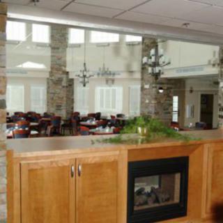 A spacious and elegant dining area with wooden furniture and decorative mirrors on the walls.