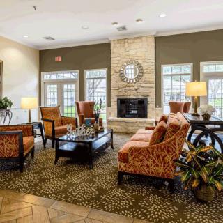 A stylish and cozy living room with modern furniture and a central fireplace.
