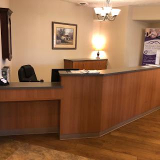 A welcoming reception area featuring a wooden front desk and warm lighting.