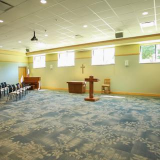 A bright and spacious chapel interior with a pulpit and seating area.