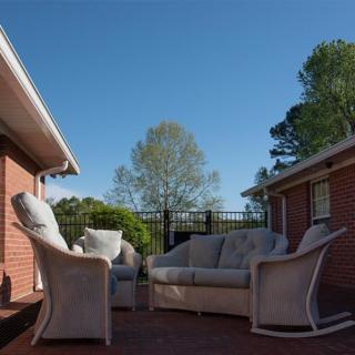 A cozy outdoor patio with comfortable furniture set between two brick buildings.