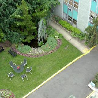 A serene garden space with outdoor seating and lush greenery.