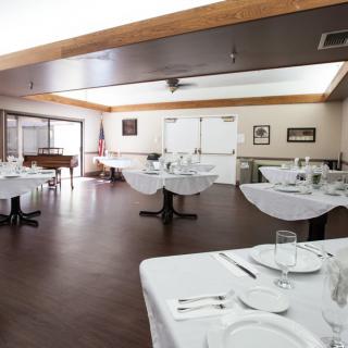 An empty restaurant dining room with neatly set tables.