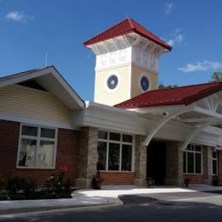 A charming building featuring a prominent clock tower under a clear blue sky.
