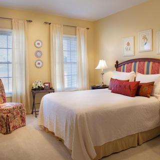 A cozy bedroom with a large bed, soft lighting, and elegant decor.