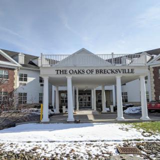 The entrance of The Oaks of Brooksville, a cozy retirement community surrounded by snow.