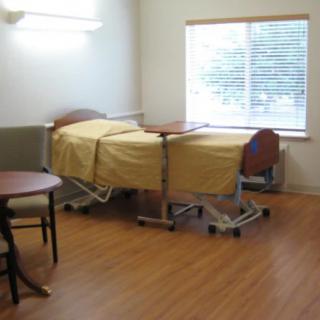 A hospital room with a medical bed and a window.